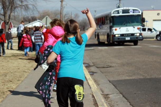 Elementary students wave to the boys basketball team as they swing through the Reeves HInger school parking lot Friday morning on the way to Odessa for their area round game.