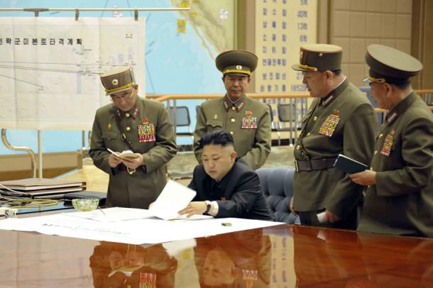 A photo provided by Korean Central News Agency (KCNA) shows North Korean leader Kim Jong Un, center, on March 29, 2013, signing an order putting rockets on standby after an urgent meeting with top generals. (KCNA/Xinhua/Zuma Press/MCT)