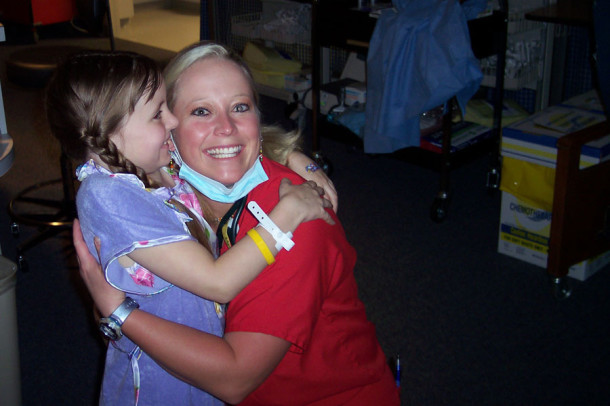 While in undergoing cancer treatment, 7-year-old Avery Cummings hugs a nurse.