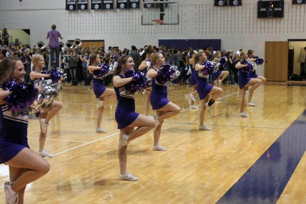 The cheerleaders lead the juniors and seniors in the fight song at the homecoming pep rally while the Canyon High school band plays behind them.