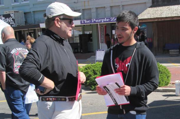 Senior Jaziel Quintana visits with a man at Fair on the Square about the issue of human trafficking.