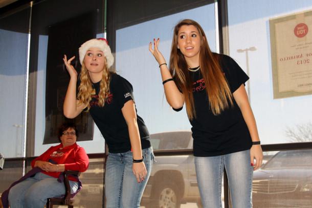 Juniors Kayla Walsh and Alexis Cuellar sign the song “Santa Claus is Coming to Town” during the American Sign Language Honor Society Book Fair Dec. 14. 