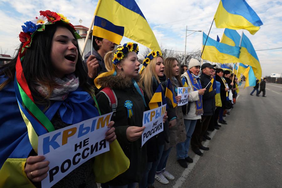 Anti-war demonstrators hold signs which read, Crimea is not Russia, during a protest action in Simferopol, Ukraine, on Friday, March 14, 2014. 