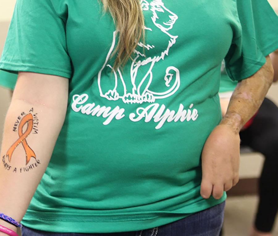 Camp+counselor+Breanna+Francis+shows+off+the+camp+logo+and+a+hand-painted+symbol+of+her+fight+against+cancer.+Francis+attended+the+camp+before+becoming+a+camp+counselor.