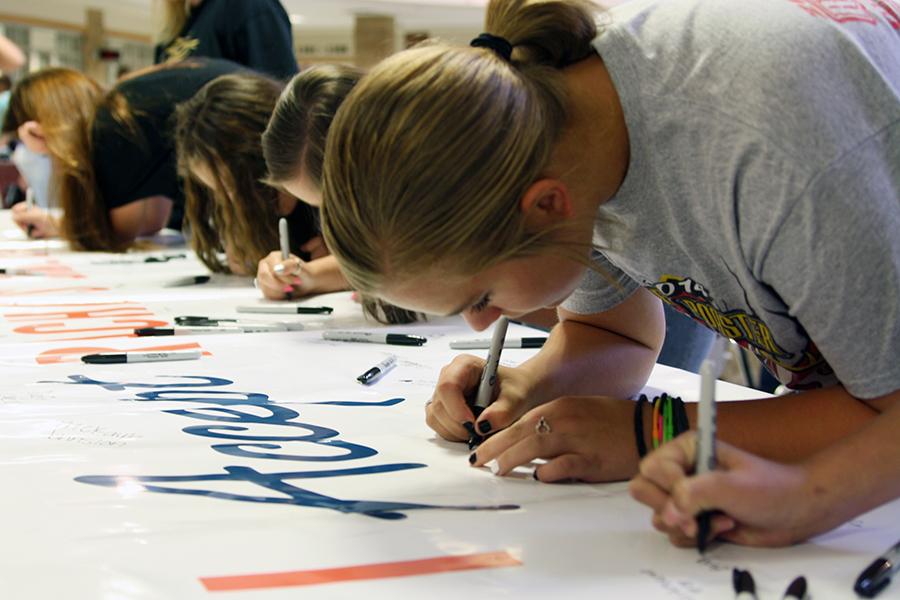 Students sign the I Accept Rachels Challenge poster in the commons. By signing the poster, students  pledge to carry out Rachels five challenges.