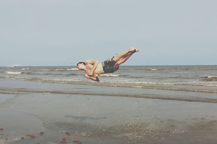 Junior Tanner Cromeens tumbles on the beach at Galveston, Texas. Cromeens vacationed in Galveston for a week to visit the beach and Schlitterbahn.