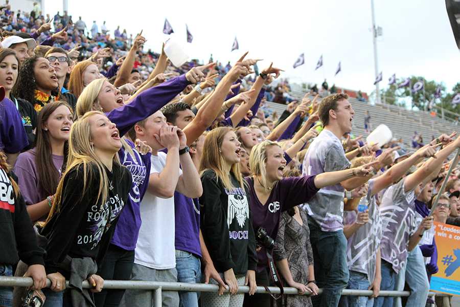Students demonstrate their purple pride by cheering on the football team.