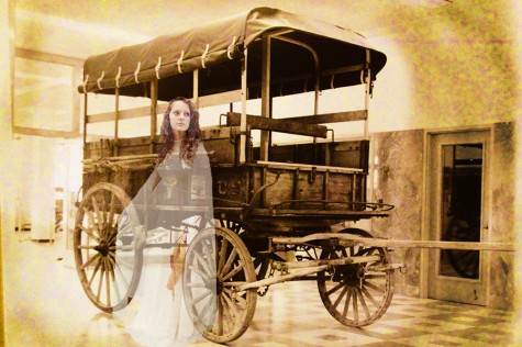 Then a sophomore, 2014 graduate Maisie Dyer portrays Sarah Jane in this photo illustration with the World War I wagon that some say is haunted by a ghost named Sarah Jane. The wagon now sits in storage among other vintage vehicles. Amid rumors that the wagon had to be put into storage because of numerous complaints from museum guests about the woman who was always seen  hovering around the wagon, Warren Stricker, director of the research center at the PPHM, said the wagon is in storage because its prior display location is now used for other museum pieces.