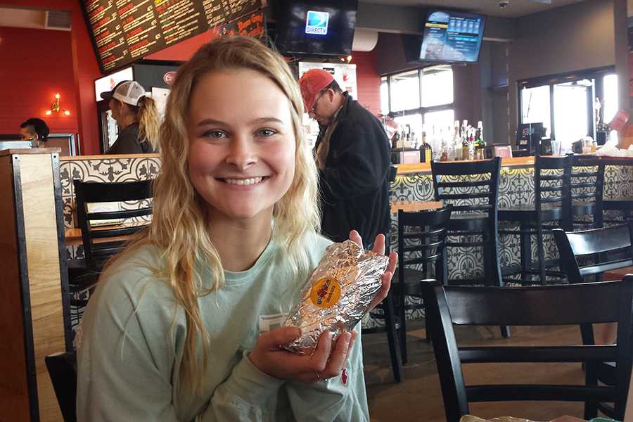 Senior Kayla Walsh shared a burrito with a friend during a staff visit to Torchys Tacos.