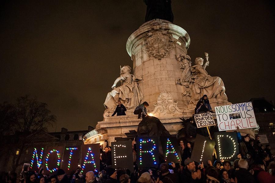 People hold placards with LED lights displaying the message "not afraid" during a rally in support of Charlie Hebdo on the Place de la Republique in Paris on Wednesday, Jan. 7, 2015, after an attack at the headquarters of the satirical newspaper killed 12 people. (Julien Muguet/Maxppp/Zuma Press/TNS)