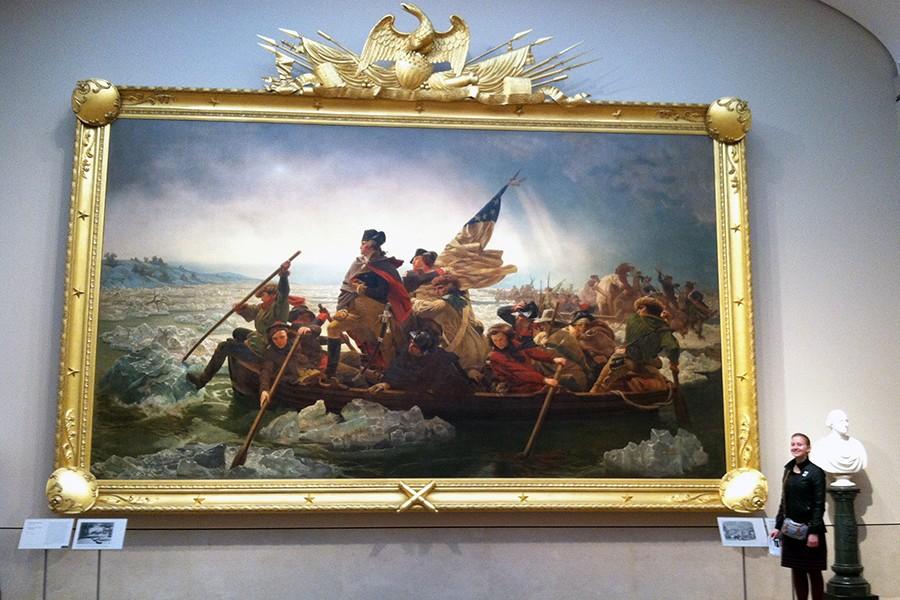 Editor-in-Chief Tasha Brown stands next to the famous painting,  Washington Crossing the Delaware, to show the immensity of the painting.