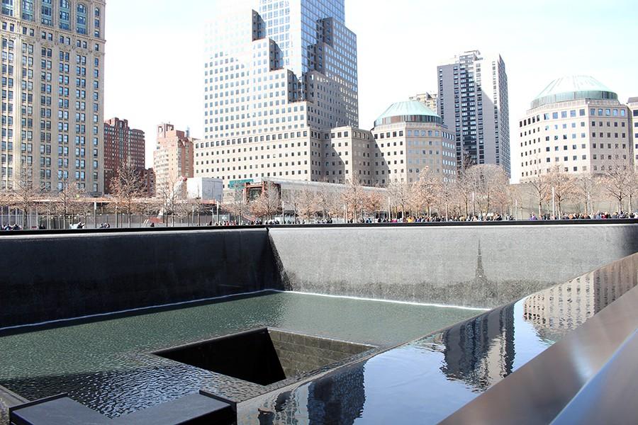 The reflecting pools sit surrounded by New York streets and skyscrapers.
