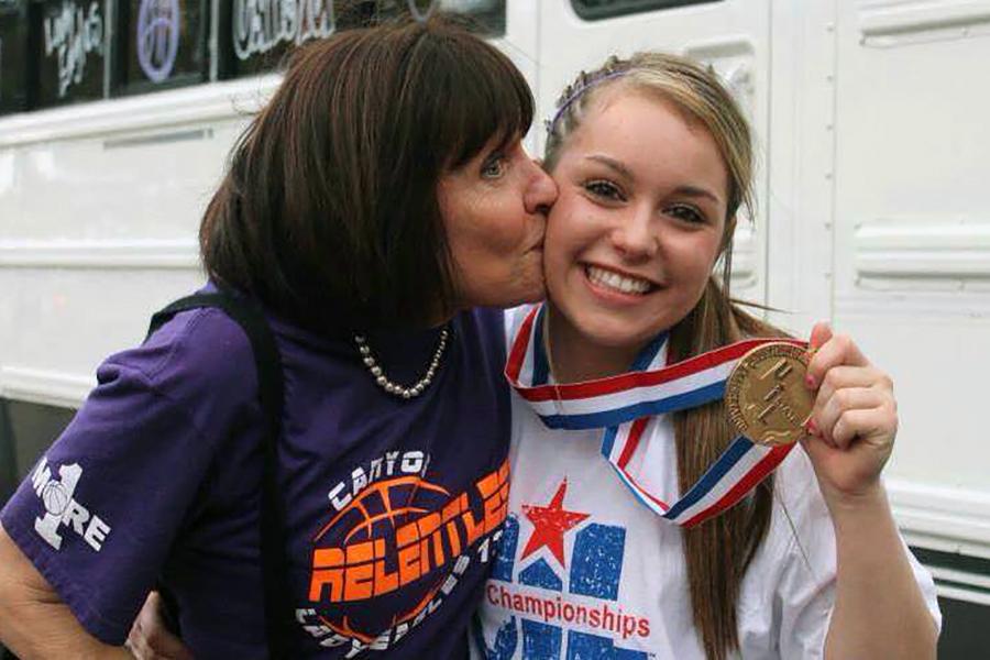 Spanish teacher Sheila Evans kisses senior Savannah Bartlett on the cheek after the Lady Eagles basketball team won state.