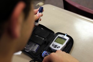 Junior Evan Walton checks his blood sugar with a home blood glucose meter. His blood sugar reads 266, which is higher than the average.