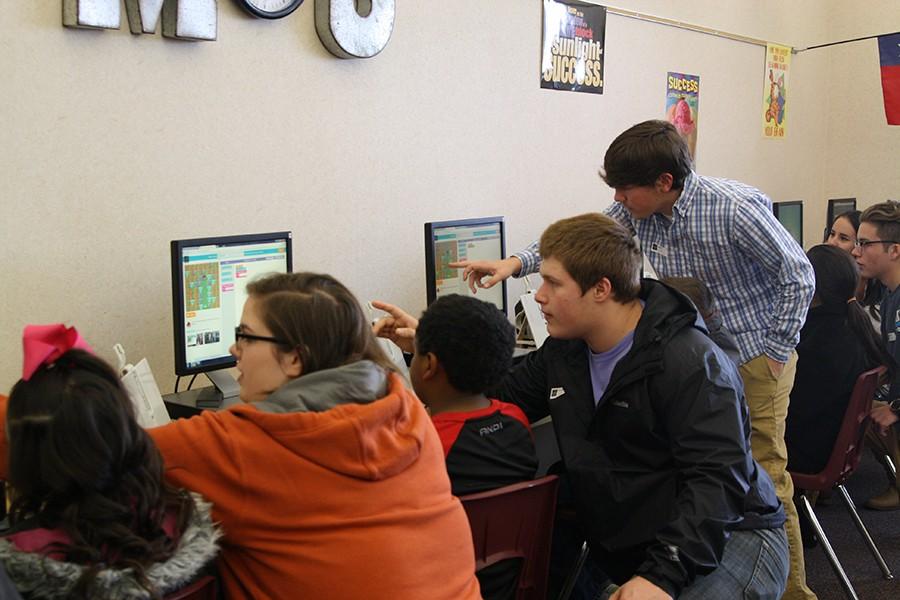 High school students help fourth graders with Hour of Code.