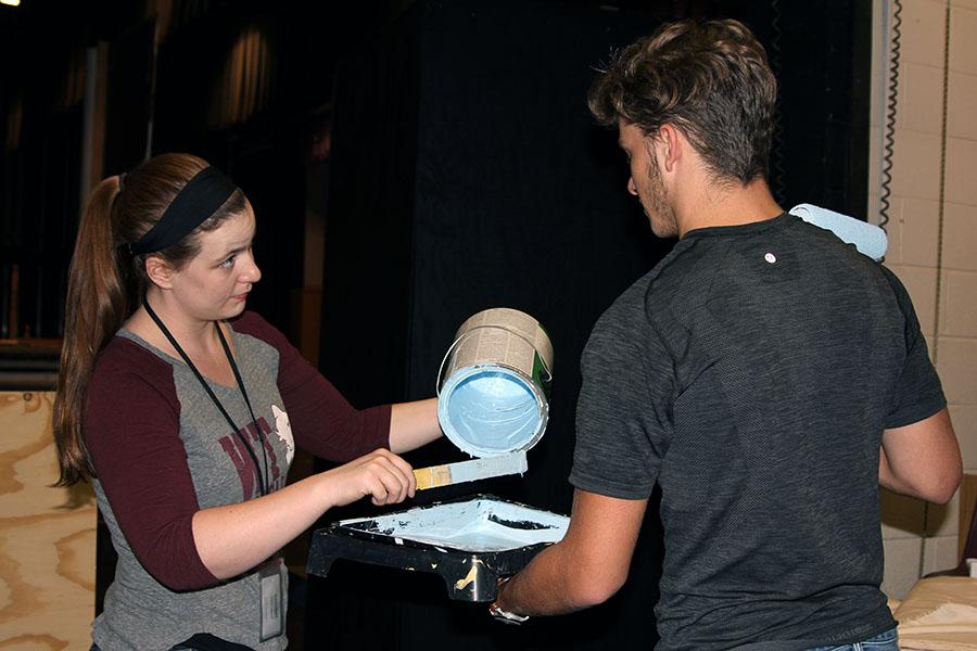 Theater arts teacher Kylie Howell pours paint for junior Brantley Spinks as they work to prepare the set for the upcoming fall musical.
