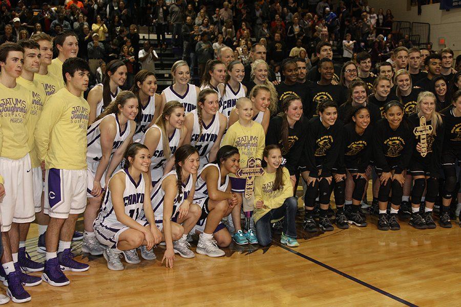 The girls and boys basketball teams crowd around 9-year-old Tatum Schulte for the Coaches vs. Cancer event. Amarillo High donated $1,200 to the Schulte family.