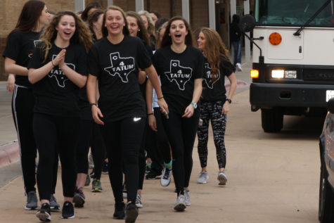 The girls basketball team walks down the bus lane during the school send-off for the state tournament.