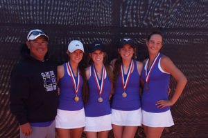 Head tennis coach John Gonzales stands alongside seniors Abi Dillehay and Berkley DeLong and juniors Sarah Gilliland and Shelbi Braudt after the district competition.