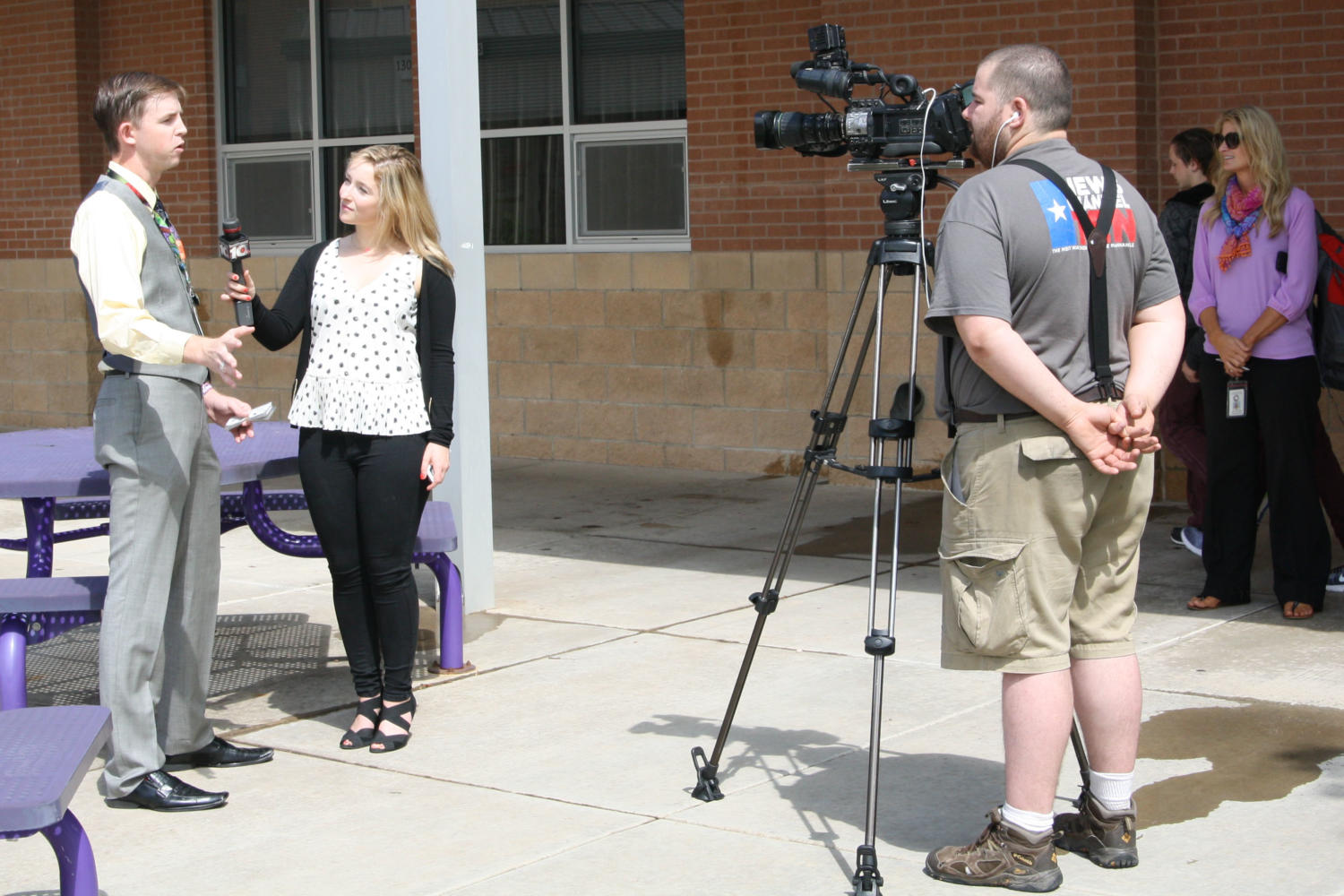 News Channel 10 reporter Marcy Marbut interviews physics teacher Chris Roberts as District Communication Director April McDaniel observes. 