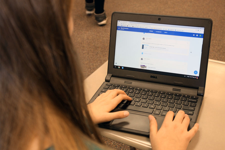 A student scrolls through a Google Classroom page in class.