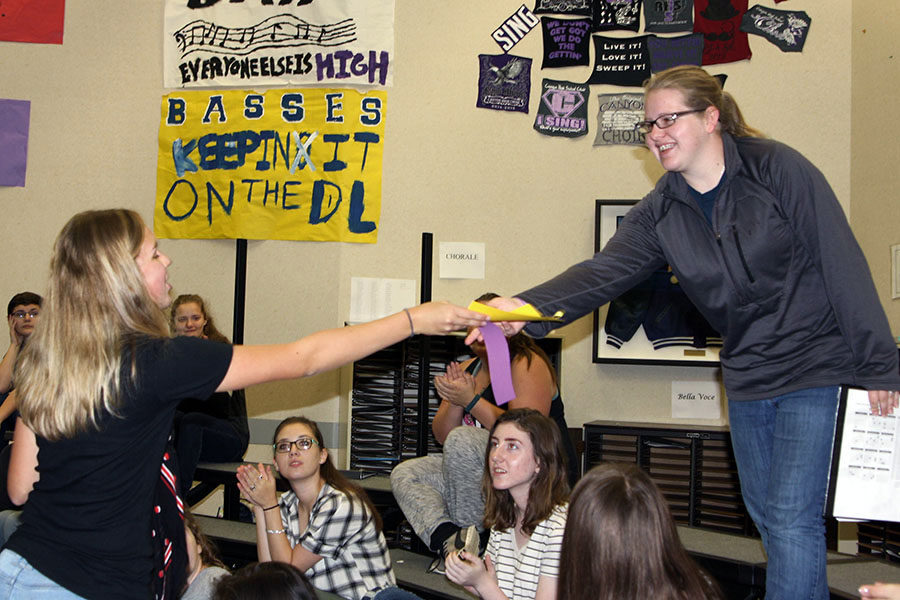 Senior NHS Officer Erica Perez presents Meghan Kempf with the ribbon indication admission to NHS. 