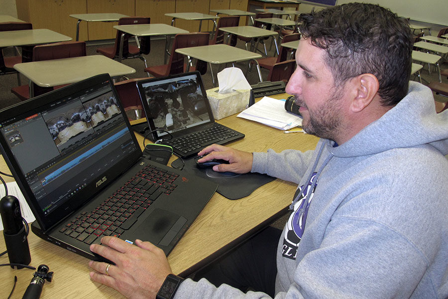 Coach Charles Johnson edits video in his classroom. Johnson is the sponsor of the new Video Production Club.