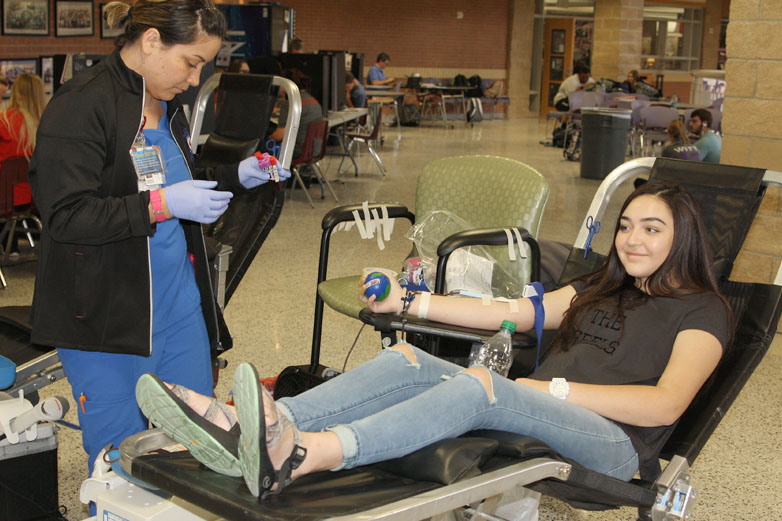 A Coffee Memorial Blood Center worker takes blood from senior McKenzie Hampton at the 2016 fall blood drive.