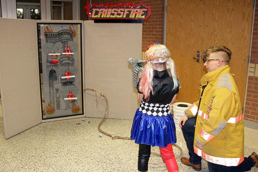 Senior Brendon Eminger monitors the volunteer firefighters stall, which features a dart gun and several targets.