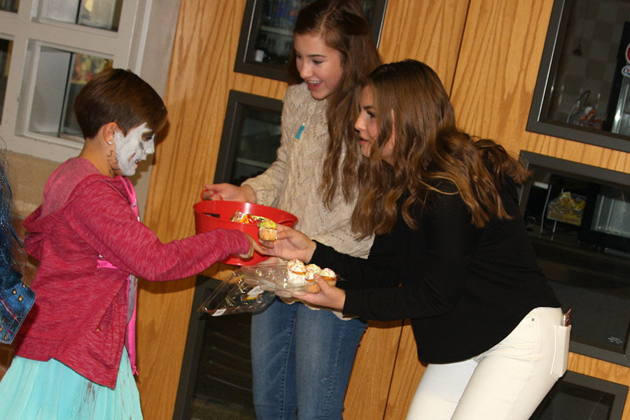 Freshmen MaKynna Cranmer and Abigail Ruiz help host the Student Councils cupcake walk. 