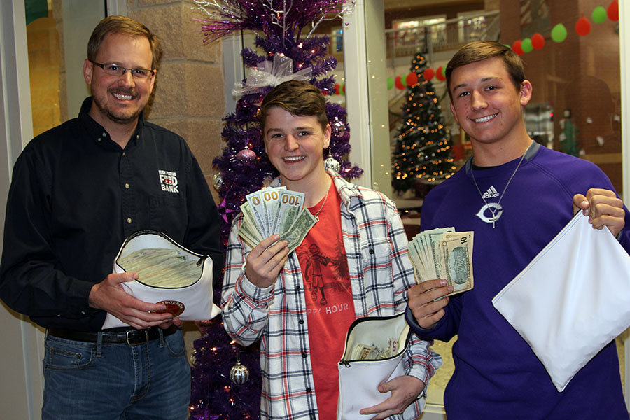 Canyon High STUCO representatives Parker Duggan and Kaden McPherson present $5,231 to High Plains Food Bank excecutive director Zack Wilson.