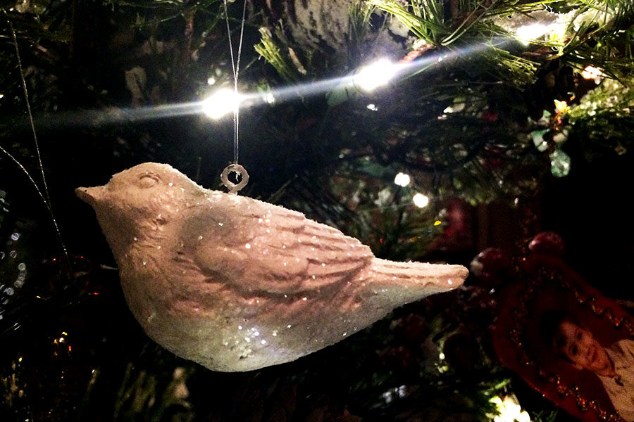 A dove ornament hangs from the Christmas tree.