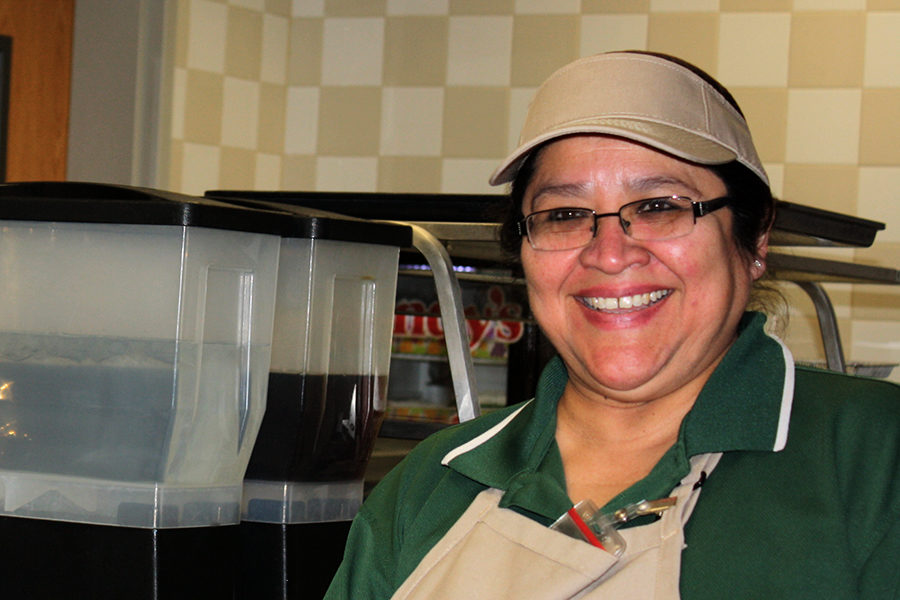 Cafeteria manager Lisa Martinez stands behind lunch line. 
