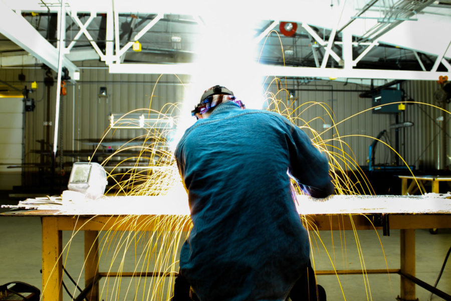 A student in the manufacturing academy welds in class.