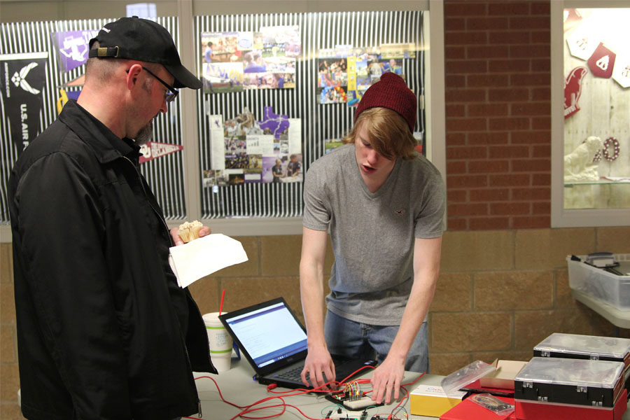 Senior Nicholas Davis shows off his science project to a visitor at the STEM table.