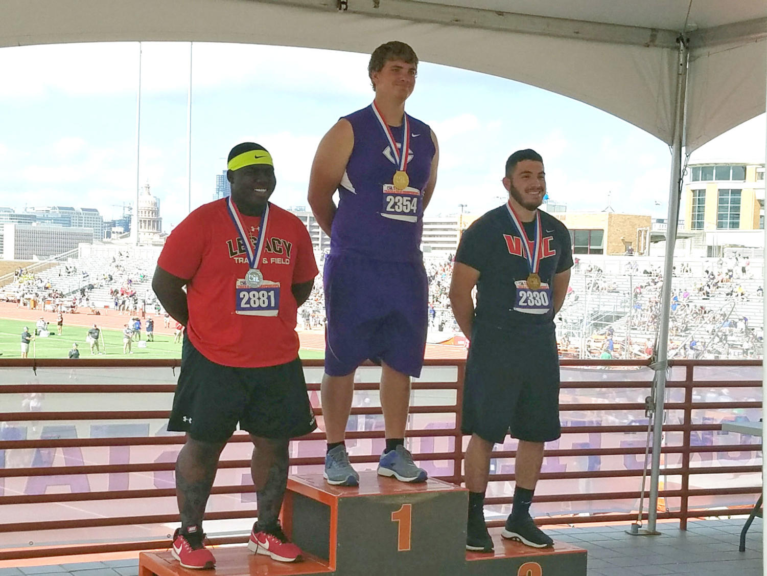 Isaac Huseman receives his first place state medal in shot put at the State UIL Track and Field Meet in Austin.