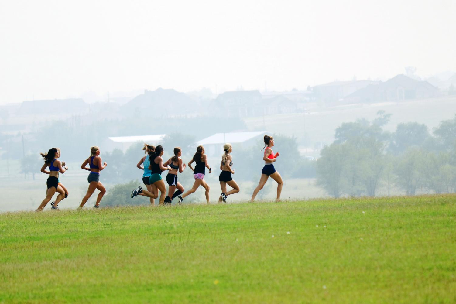 The girls cross country runs through the area behind Canyon High School during a recent workout.