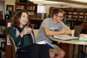 Seniors Erin Sheffield and Wildon Woolley discuss the opening of the CodeBreaker game in the library Oct. 1.