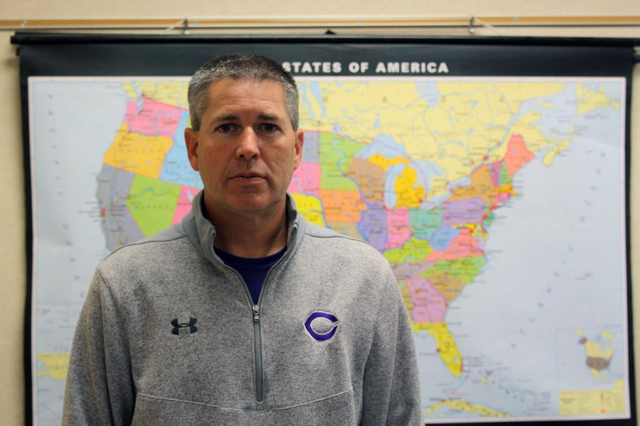 Veteran and history teacher Jeremy Chettinger stands in front of a map of the United States.