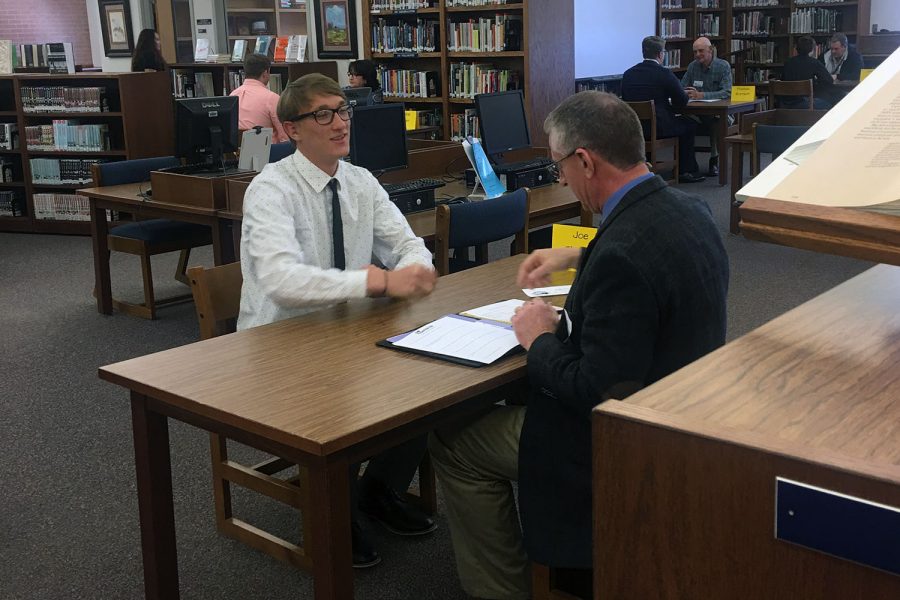 Graduate Miles Kuehn interviews with a community member at last years Interview Week in the Canyon High library.