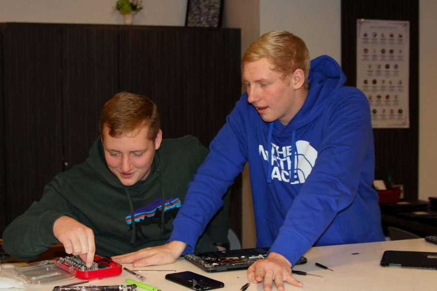 Sophomore Max Smith and senior Cooper Smith repair a Chromebook using skills they learned during the Dell training.