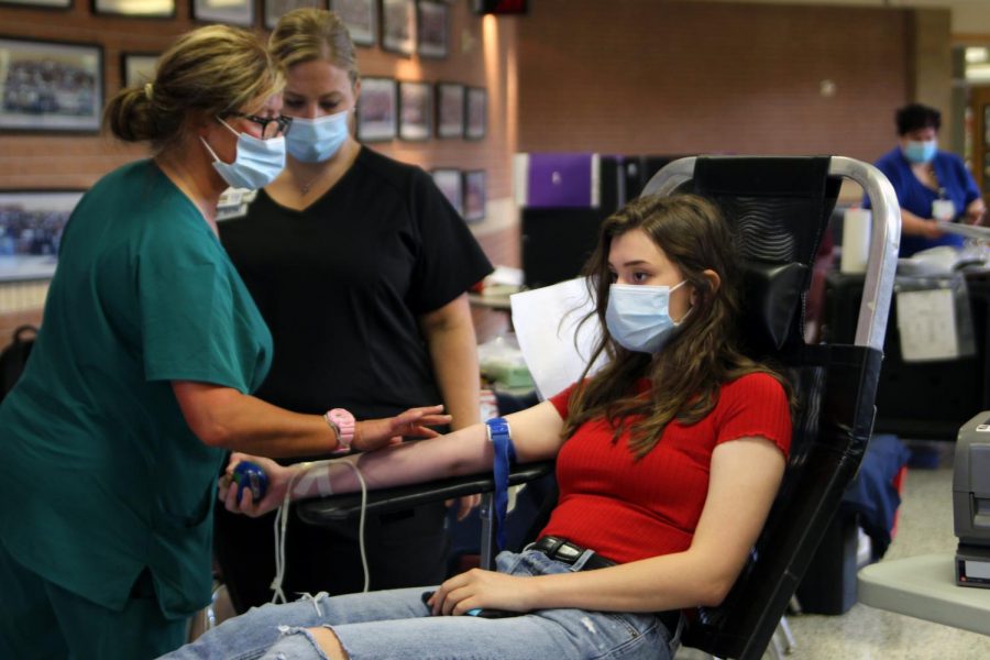 Squeezing a stress ball, senior Kat Clark ensures blood flow through her arm while donating at the fall blood drive. For the last 10 years, Coffee Memorial Blood Center and Canyon Highs Key Club have partnered to host and provide a place for students and staff to donate.