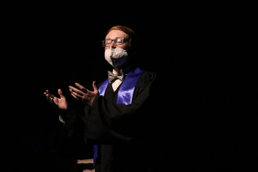 Senior Ryan Cox is shown in the first scene in character lecturing many educated men. Cox plays Professor Maudsley in the One-Act show. “My character and I have this beautiful love-hate relationship because I love being able to just say something that is so factually wrong, but to everyone else in the canonical scene it’s the truth, and it’s hilarious in my mind, Cox said. However, I do hate the fact that Professor Maudsley was a sexist man.” Cox said COVID-19 mask mandates make it difficult to project sound into the audience. “We have to project more and we have to make sure to enunciate because the sound that comes out of our mouth gets halted by the masks.” 