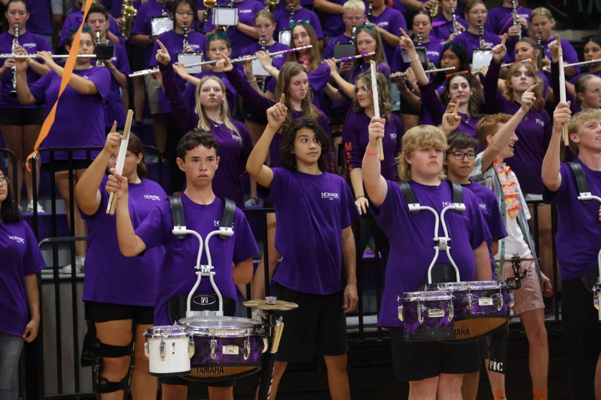 Drum section holding up a one with their drum sticks.