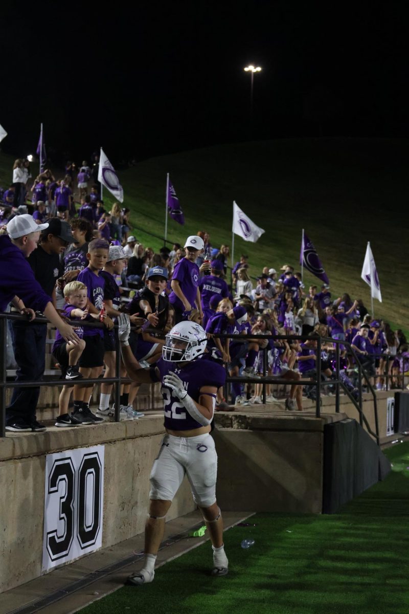 Rudy Flores (12) high-fives the student section after a touch down.